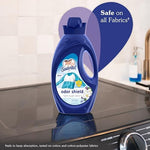 Suavitel Fresh Breeze liquid softener bottle next to freshly folded clean white towels