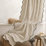 Linen textured boho bathroom curtain with twelve included metal hooks.