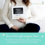 White ultrasound keepsake frame with gold and silver text showcasing a gender neutral nursery gift idea.