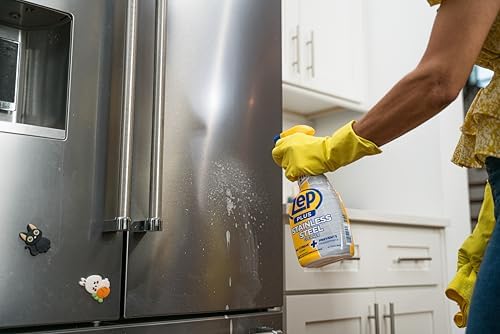 Zep Plus formula being sprayed onto a modern kitchen appliance surface for streak free polishing.