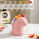 Six stainless steel mini food picks with colorful ball tops displayed outside the stand