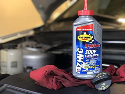 Rislone ZDDP engine oil additive bottle next to engine components