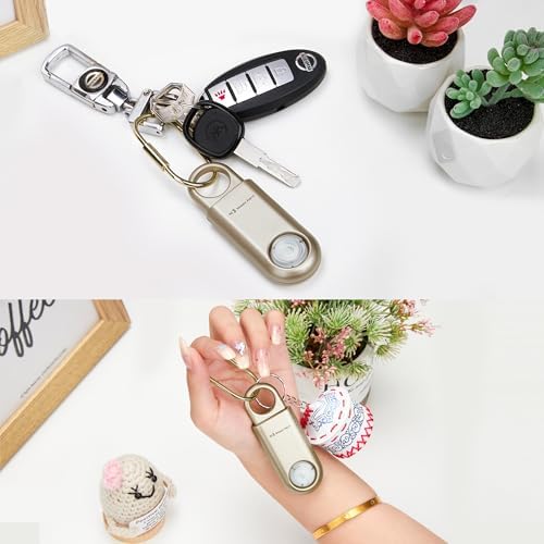 Close up of gold personal safety alarm with carabiner attachment