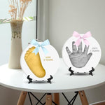 Finished personalized baby footprint ornament decorated with gold paint and custom stamped lettering.