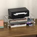Minimalist home office desk showing a keyboard stored neatly under a transparent stand
