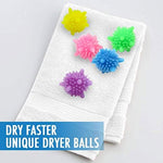 Eco-friendly laundry balls being placed into a washing machine drum with clothes.