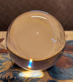 Side angle view of the transparent 70mm manipulation sphere highlighting the flawless hand-polished surface finish.
