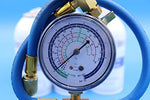 Close up of the brass charging gauge with blue hose included in the USA imported air conditioning booster kit