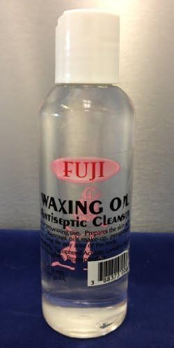 Close up look of professional hair removal oil bottle showing ingredients for soothing skin irritation and post wax residue removal