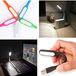 Black mini USB night light connected to a power bank illuminating a small area