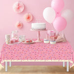 Waterproof plastic tablecloth protecting a wooden table from bright pink spills