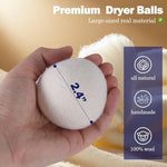 Organic wool dryer balls tumbling inside a modern laundry machine drum.