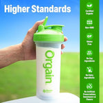 Scoop of Orgain plant-based vanilla protein powder in a glass
