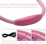 Pink wearable book light being plugged into a universal serial bus port for recharging.