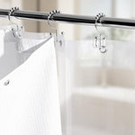 Clear PEVA shower curtain liner showing the three bottom weighted magnets holding against a bathtub