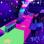 Rectangular glow party tablecloth used as a vibrant wall photo backdrop