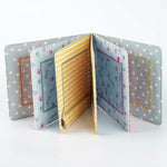 Fanna cloth photography album for infants showing a four by six inch picture being securely inserted