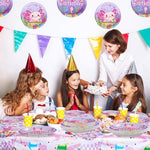 Flat lay of pink axolotl birthday party decorations and tableware