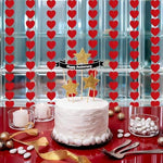 Eco friendly lightweight red heart garland draped elegantly over a bedroom headboard for a surprise anniversary celebration