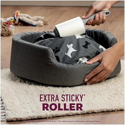 Pet hair and dander being lifted from black clothing using a sticky roller