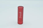 Fresh Sugar Lip Treatment open metallic red tube showing coral lip balm stick