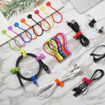 Silicone magnetic cord organizer wrap securing a white USB data charging cable on a desk.