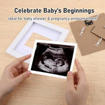Expecting parents holding the white wooden sonogram frame for a pregnancy reveal