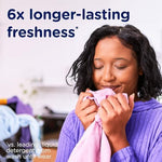 Pouring Downy Infusions laundry beads into a washing machine drum