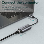 Thunderbolt 3 to RJ45 adapter by QGeeM connected to a sleek gray laptop.