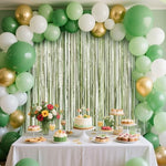 Light green metallic tinsel backdrop curtains hanging on a party wall
