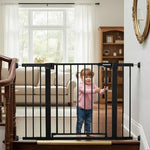 Pressure mounted safety gate installation at the bottom of stairs using black wall savers.