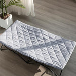 Side angle view of the grey Biloban padded travel bed sheet highlighting its quilted cushioning thickness.