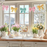 Generic brand pastel bow garland backdrop arrangement on a wall for a feminine coquette birthday celebration.