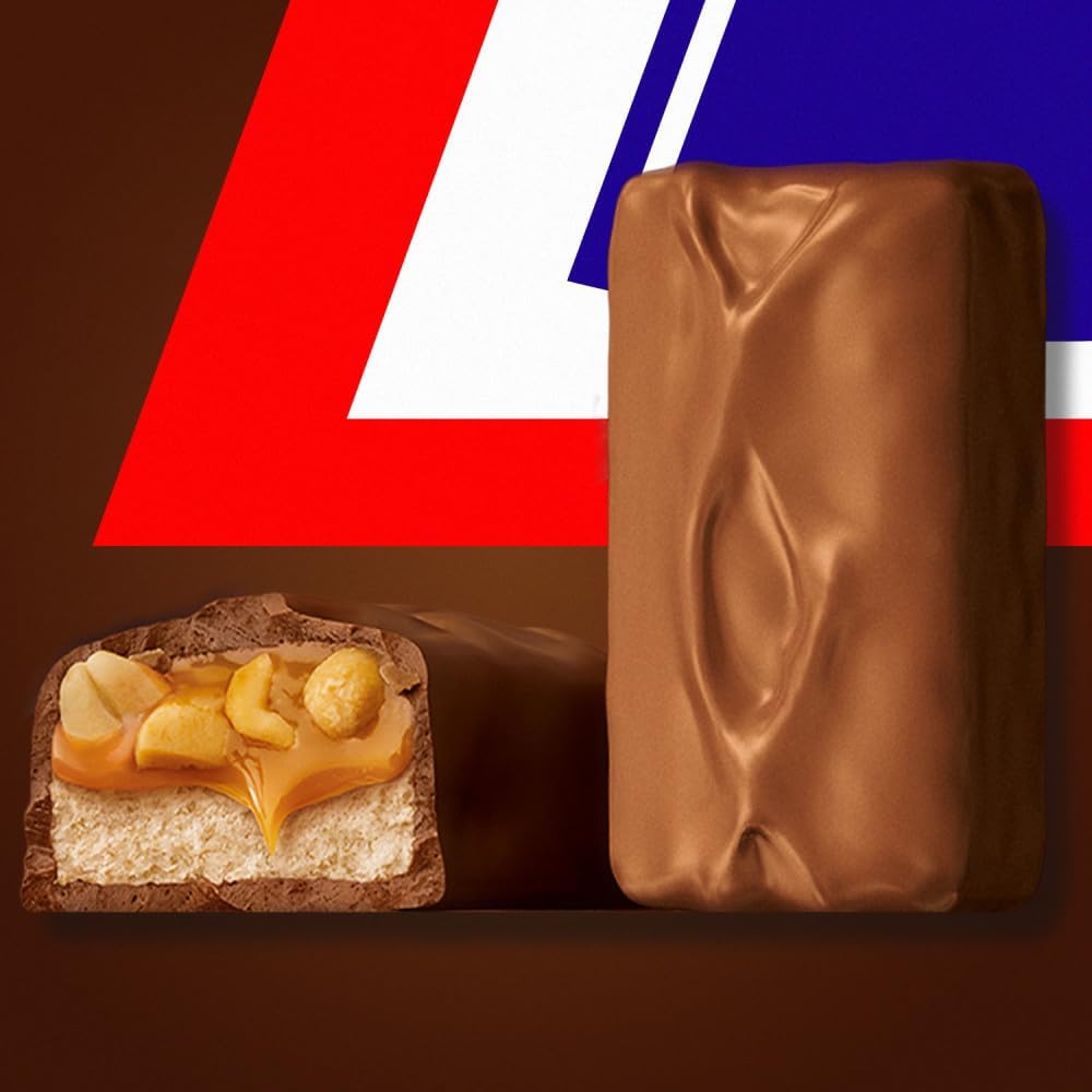 A person holding an authentic individually wrapped Snickers Fun Size bar to show its real-life scaling and dimensions.