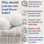 Organic wool dryer balls being placed directly into a tumble dryer with clothes