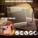 Glovion flexible reading light bent at an angle illuminating a laptop keyboard in the dark