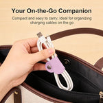 Heart shaped leather cable holder close up with metal snap button closure fastened around earbud wires
