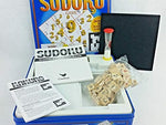 Open Cardinal logic game tin with wooden pieces and sand timer