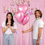 Bachelorette party photo booth background featuring light pink metallic curtains