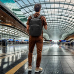 SUIKIHUM black minimalist daypack being worn by a commuter showing ergonomic shoulder straps