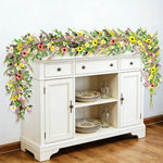Handmade YLOLUL artificial flower vine draped elegantly over an indoor doorway frame for home decoration.
