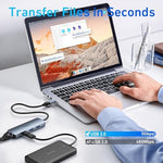 Compact portable network hub displayed next to a modern laptop demonstrating sleek professional design and form factor.