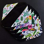 Six piece set of MissC2C charcoal cloth liners spread out showing various prints.