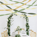 Aesthetic lifestyle image showing an eco friendly baby shower setup using sage green paper streamers.