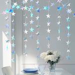 Holographic star garland decorations draped across a window frame for a birthday celebration