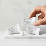 Fun Express wedding favors bulk candy mints scattered around a reception centerpiece.