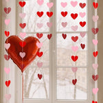 Four pack of Sincey vertical heart streamers draped elegantly over a window frame for a party
