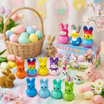 Variety of pastel rainbow and solid color bunny squishies laid out in rows.