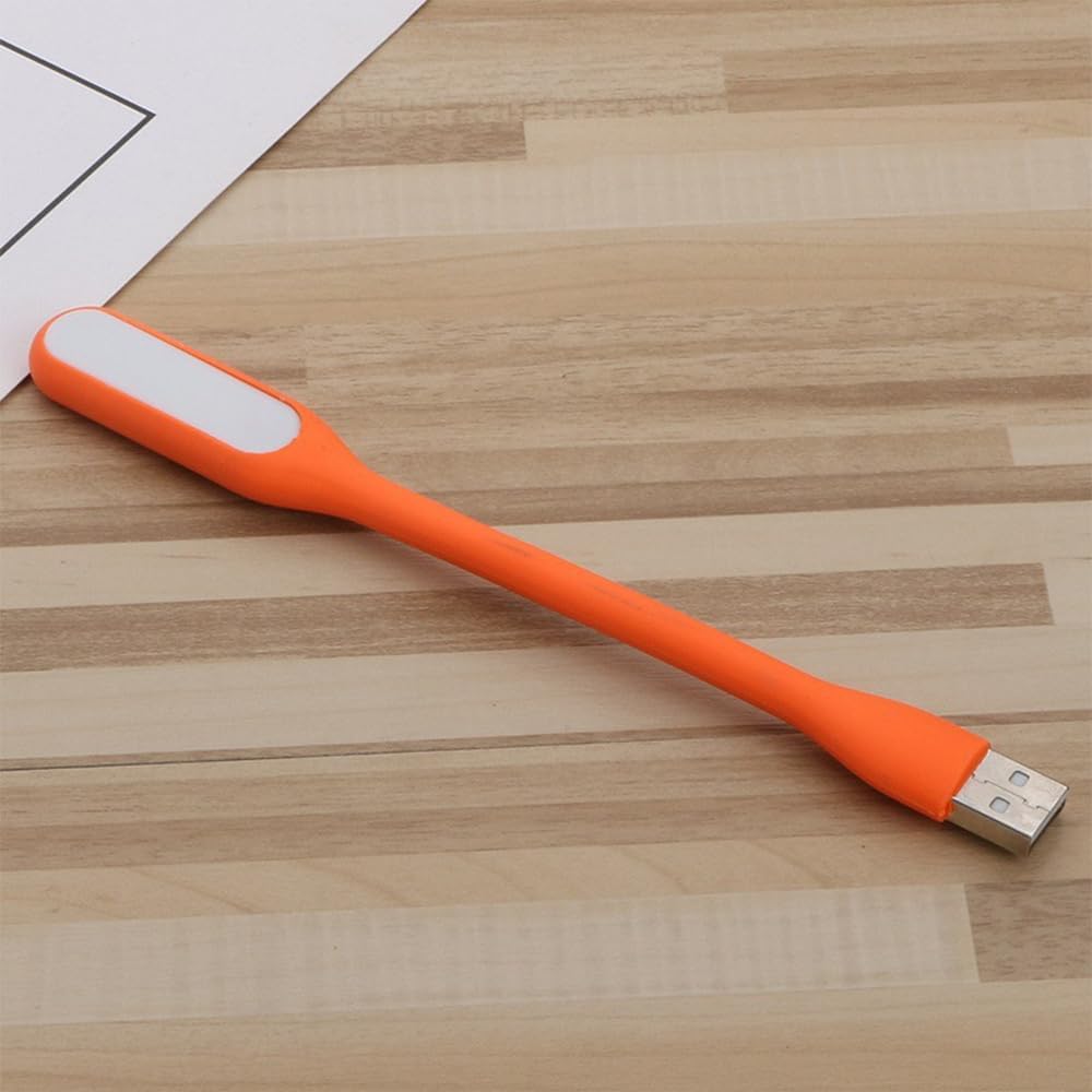 Generic flexible orange USB mini night light front view plugged into a laptop keyboard