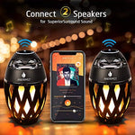 ANERIMST flame torch lantern speaker hanging from a tree branch showcasing the portable metal hook design.